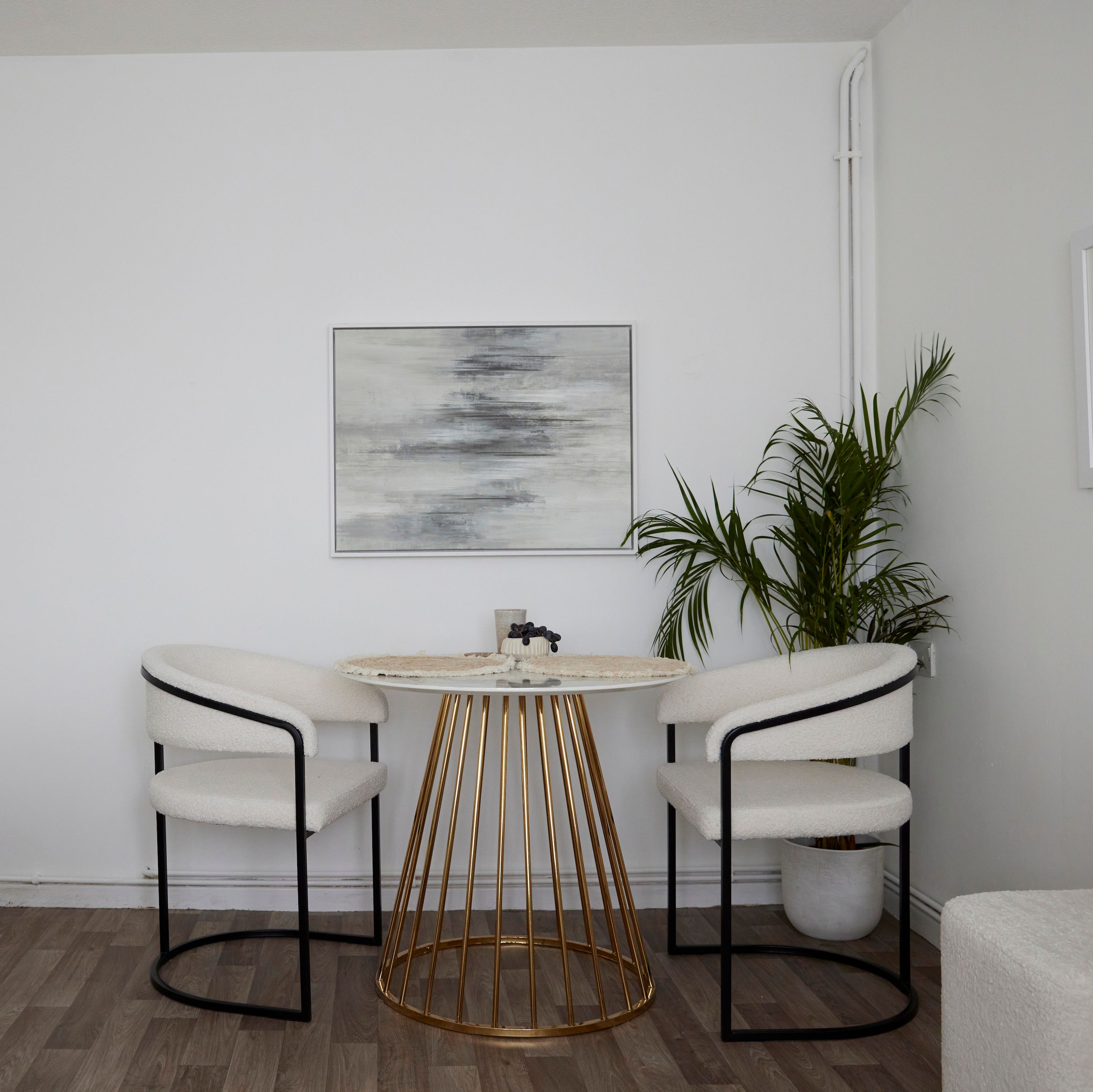 A corner of a room with a dining table set and a plant